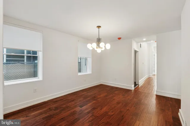 a view of a room with wooden floor and chandelier