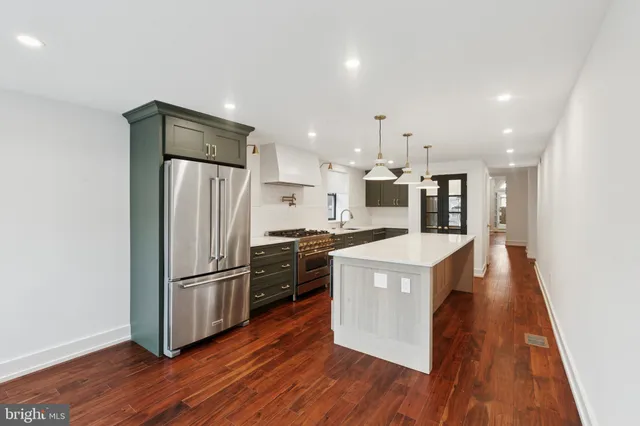 a kitchen with wooden floors and white stainless steel appliances