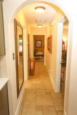 a hallway with sliding door and view of bathroom