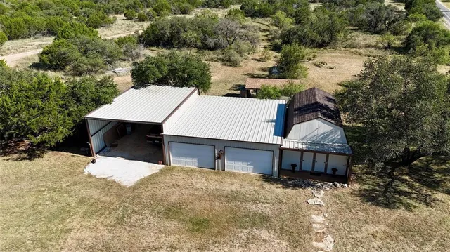 a view of a house with a yard and large tree