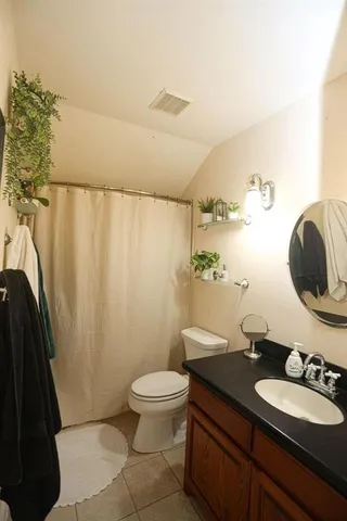 a bathroom with a granite countertop sink mirror vanity and toilet
