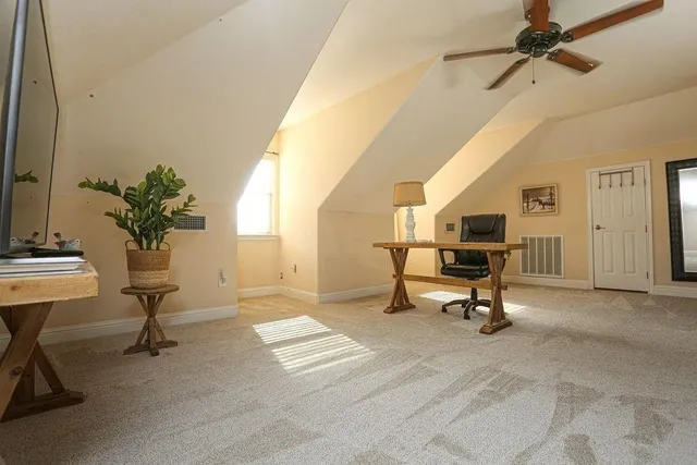 a view of a workspace with furniture and a window