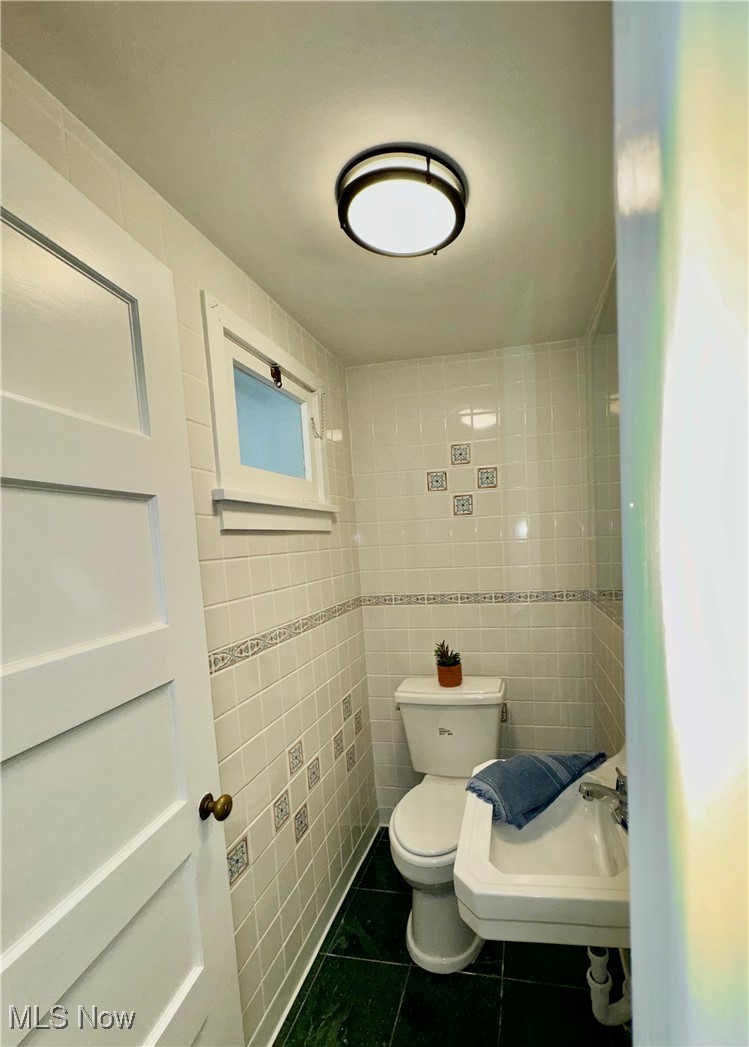 1729 East Pleasant Valley Road Independence, OH 44131 - Photo 27 of 41 Bathroom featuring toilet, sink, tile walls, and tile patterned flooring