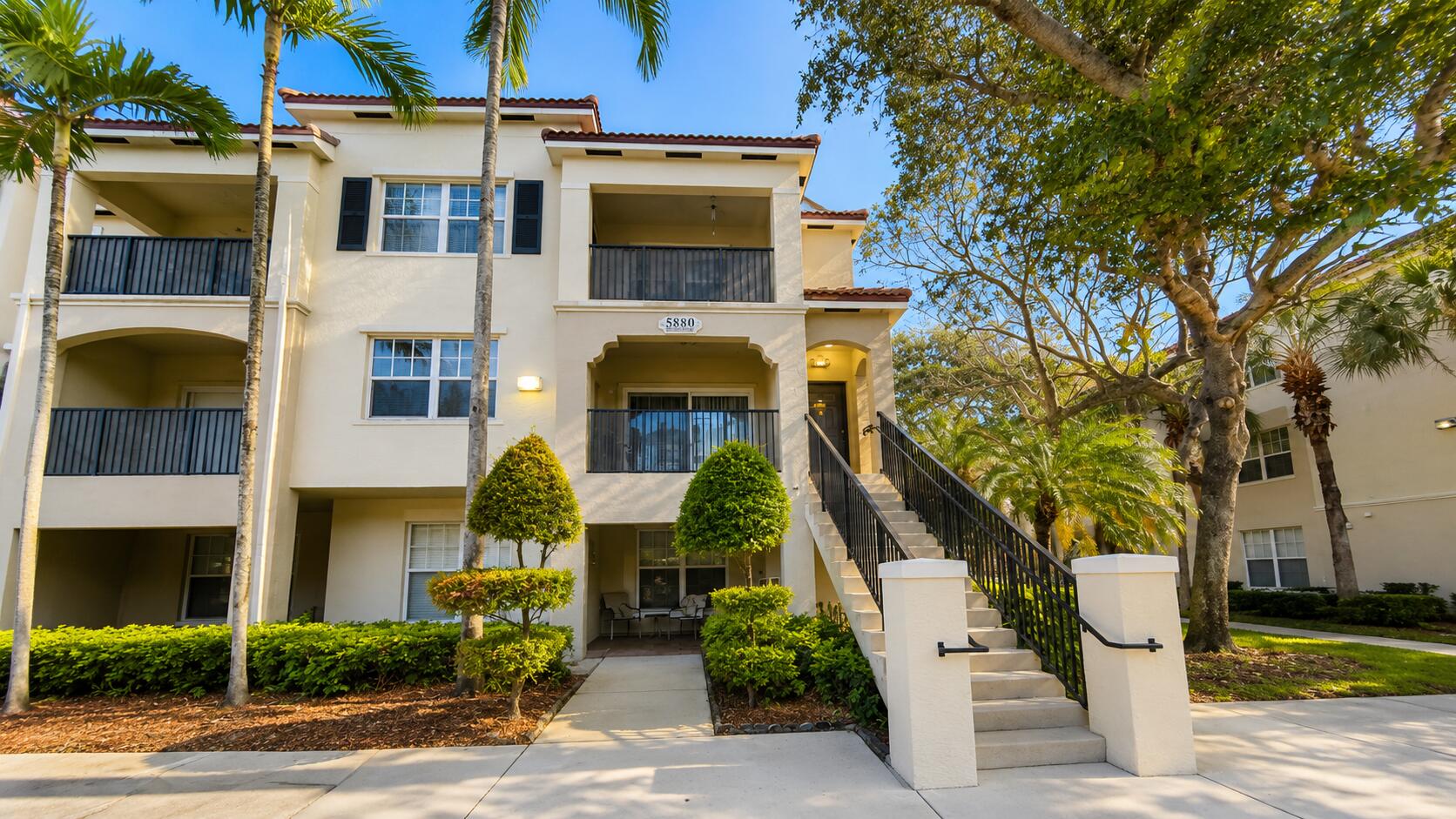 5880 West Sample Road, Unit 105 Coral Springs, FL 33067 - Photo 2 of 17 a front view of a house with a tree