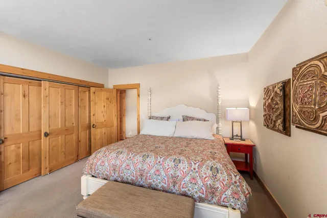 a bedroom with a large bed and a painting on the wall