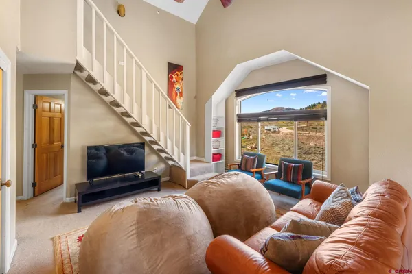 a living room with furniture a ceiling fan and a flat screen tv