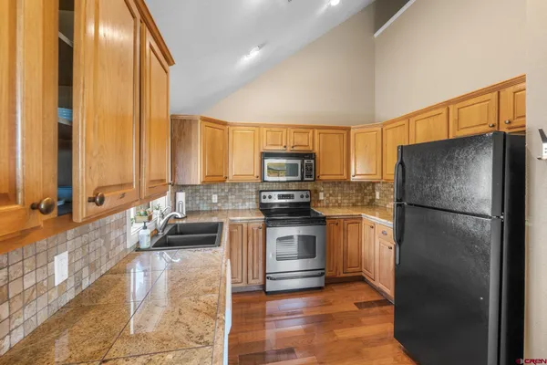 a kitchen with a refrigerator a stove top oven and a sink