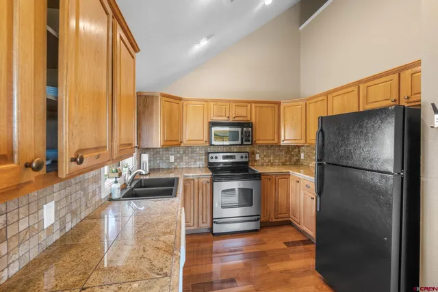 a kitchen with a refrigerator a stove top oven and a sink