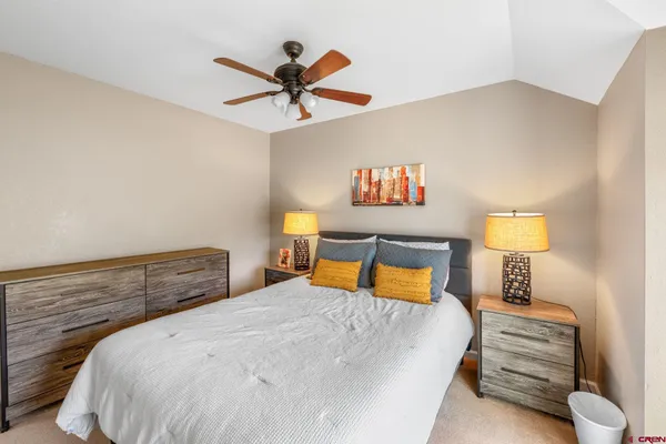 a bedroom with a bed and painting on the wall