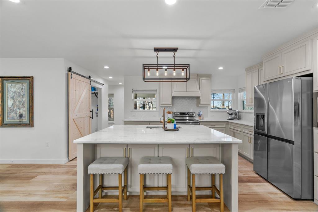 1021 Poe Street Azle, TX 76020 - Photo 13 of 38 a kitchen with kitchen island a table and chairs
