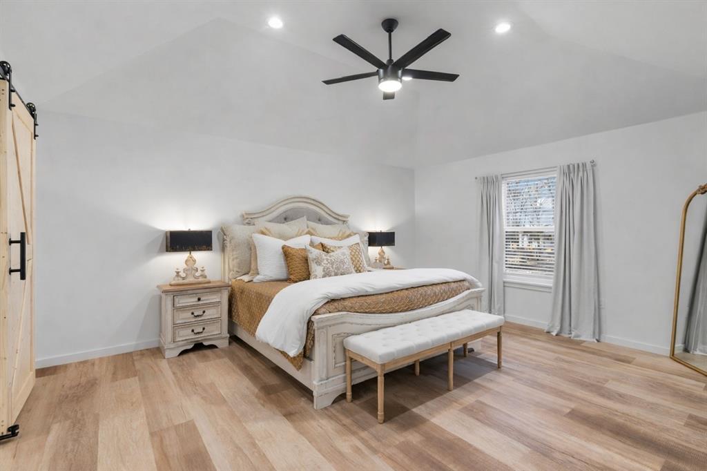 1021 Poe Street Azle, TX 76020 - Photo 19 of 38 a bedroom with a bed and a chandelier