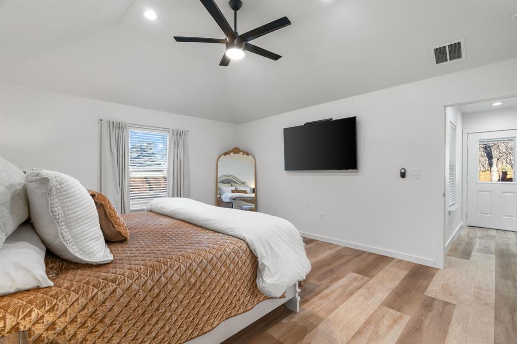 1021 Poe Street Azle, TX 76020 - Photo 21 of 38 a bedroom with a bed tv and wooden floor