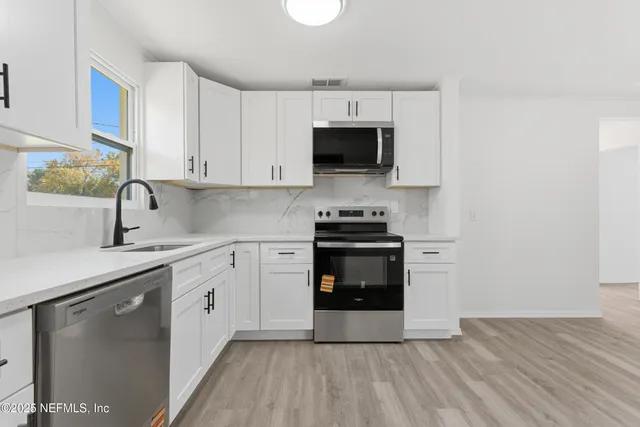 a kitchen with stainless steel appliances granite countertop a sink and stove top oven
