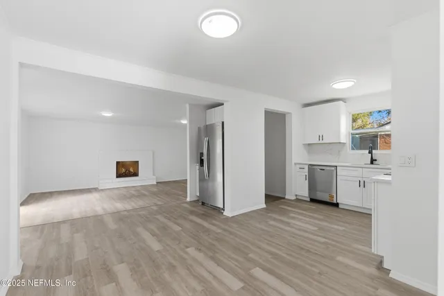 a view of a kitchen with wooden floor and a sink