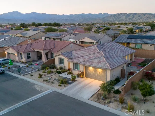an aerial view of multiple houses with a mountain