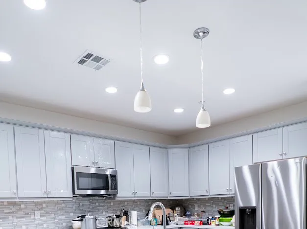 a living room with couches and a potted plant on table with wooden floor