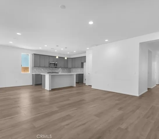 a view of kitchen with kitchen island wooden floor center island and stainless steel appliances