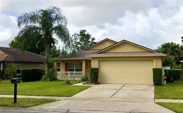a front view of a house with a yard and potted plants