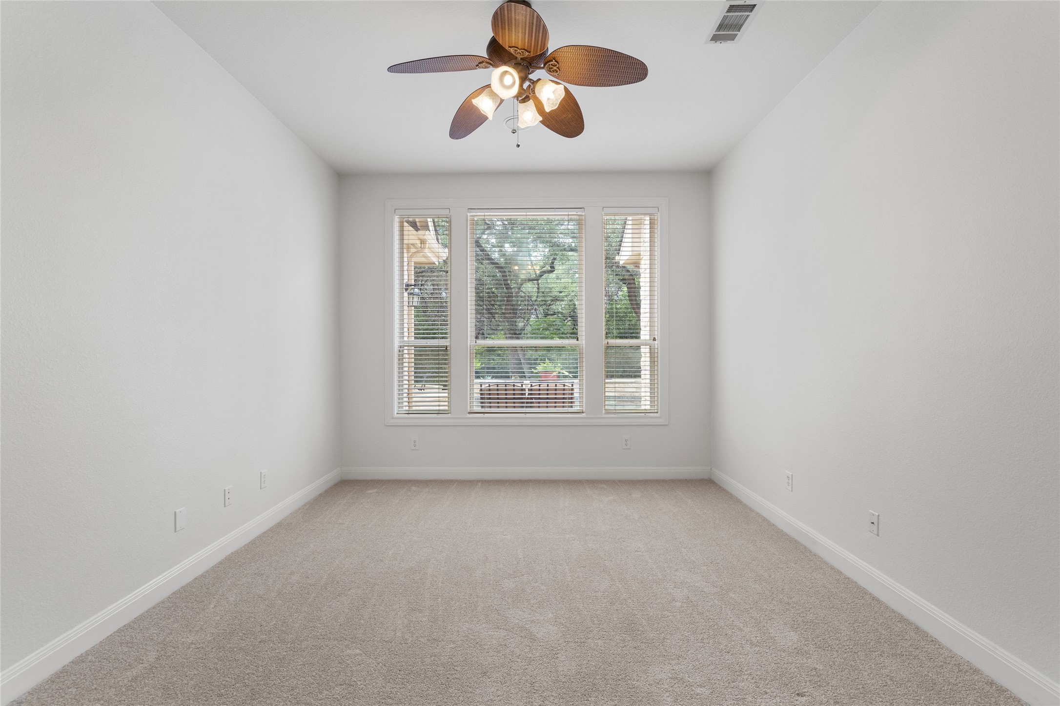 4313 Rio Robles Drive Austin, TX 78746 - Photo 26 of 40 Well-lit room with plush carpeting offers tranquil views of the surrounding trees.