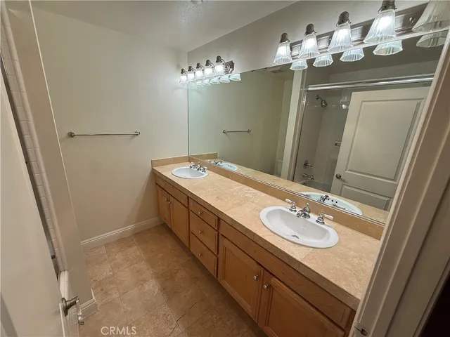 a bathroom with a granite countertop sink a mirror and shower