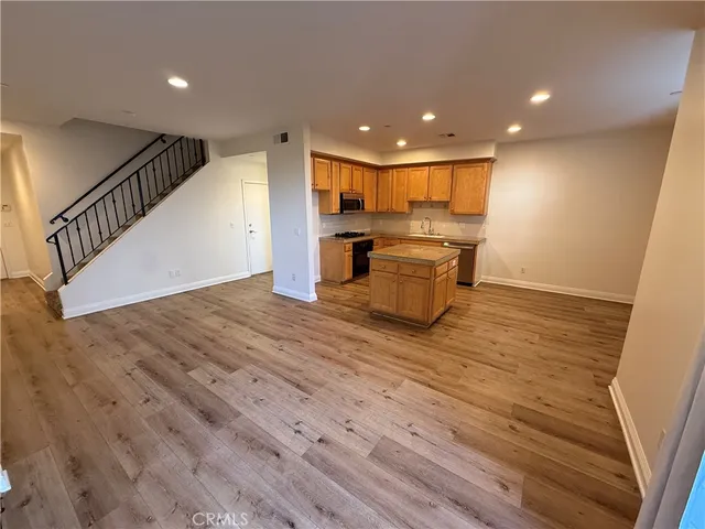 a view of a big room with wooden floor and windows