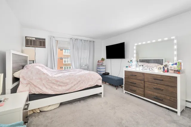 a spacious bedroom with a bed and a flat screen tv