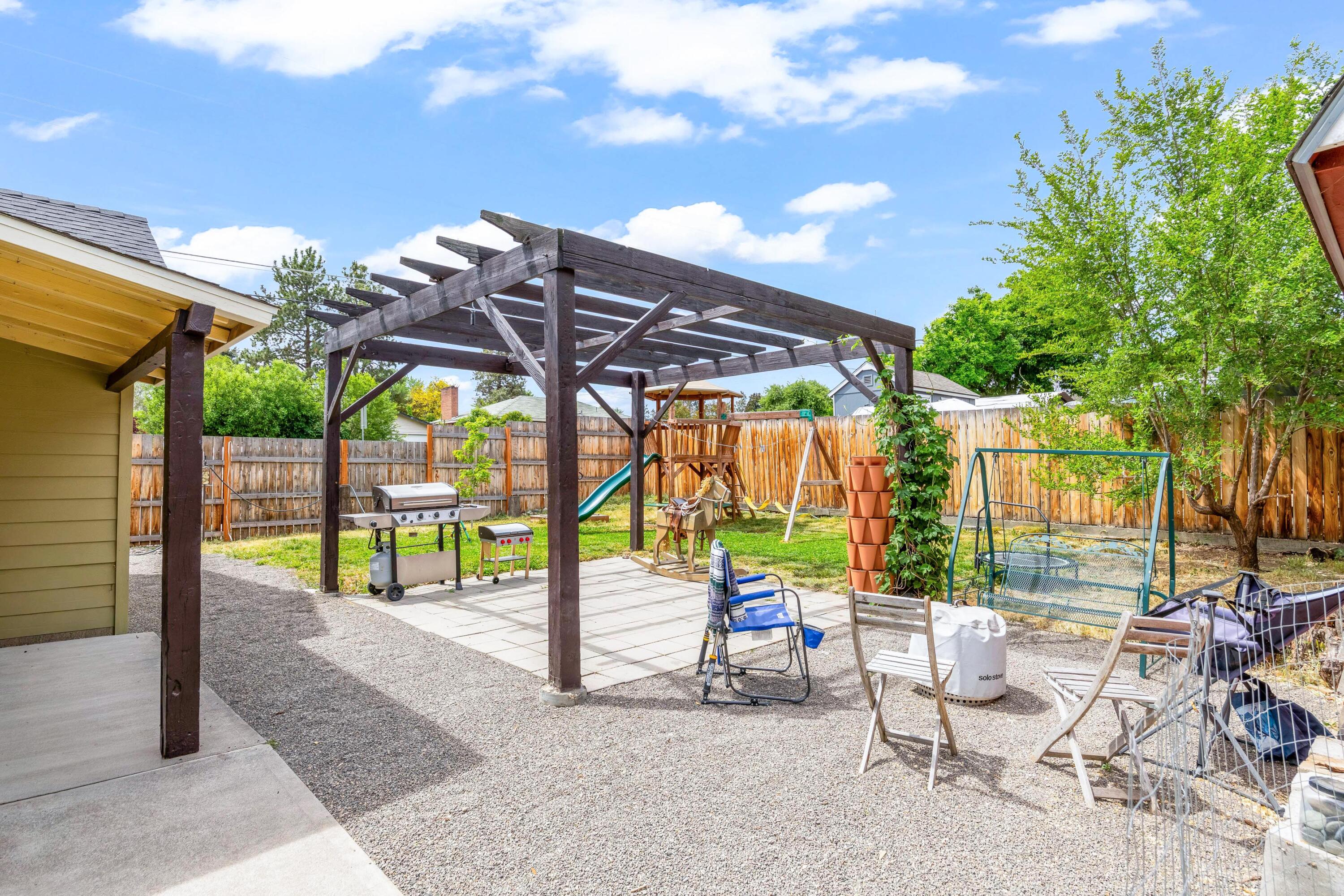 496 Southwest 2nd Street Madras, OR 97741 - Photo 26 of 37 a view of patio with a table and chairs under an umbrella with a small yard