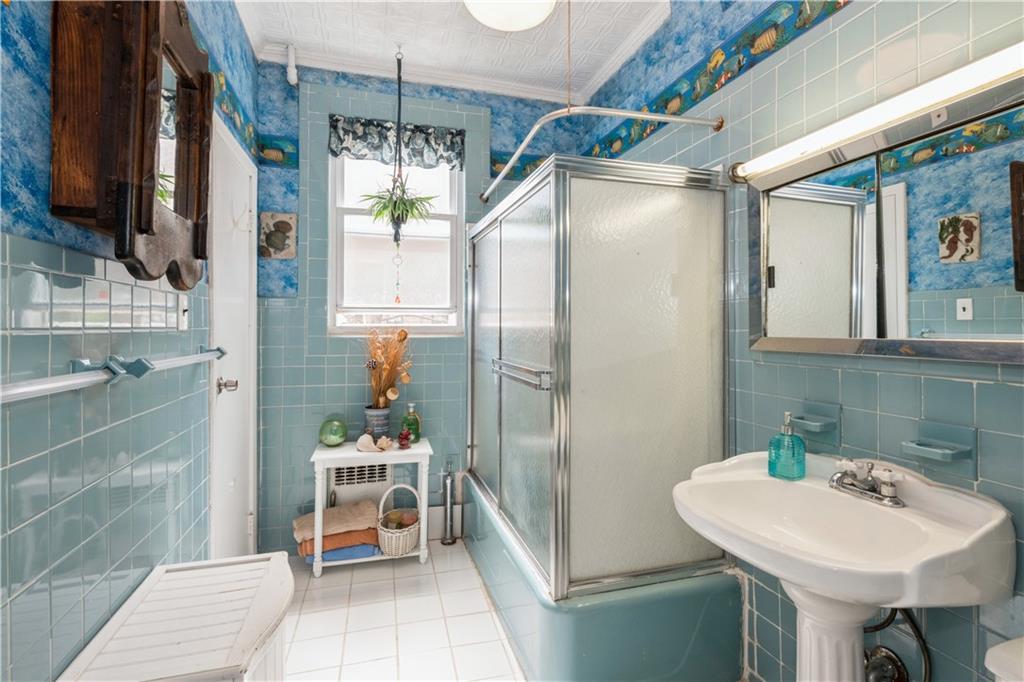 358 74th Street Brooklyn, NY 11209 - Photo 27 of 41 a bathroom with a sink a mirror and a shower