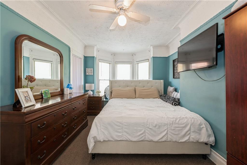 358 74th Street Brooklyn, NY 11209 - Photo 30 of 41 a bedroom with a bed and a large mirror on the dresser