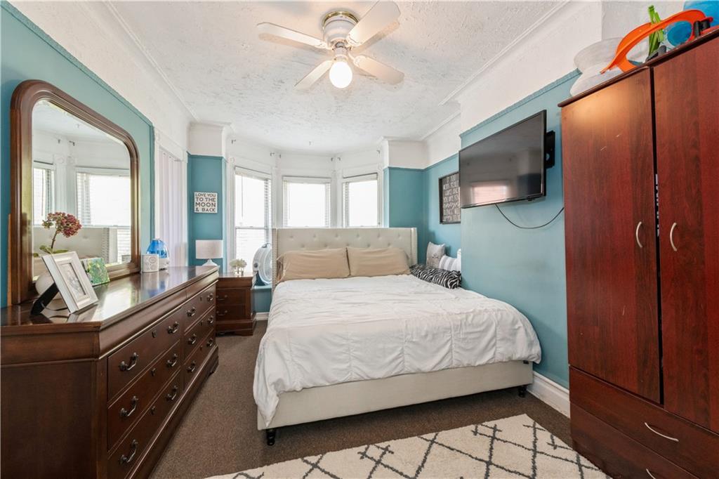 358 74th Street Brooklyn, NY 11209 - Photo 31 of 41 a bedroom with a bed and a dresser with mirror