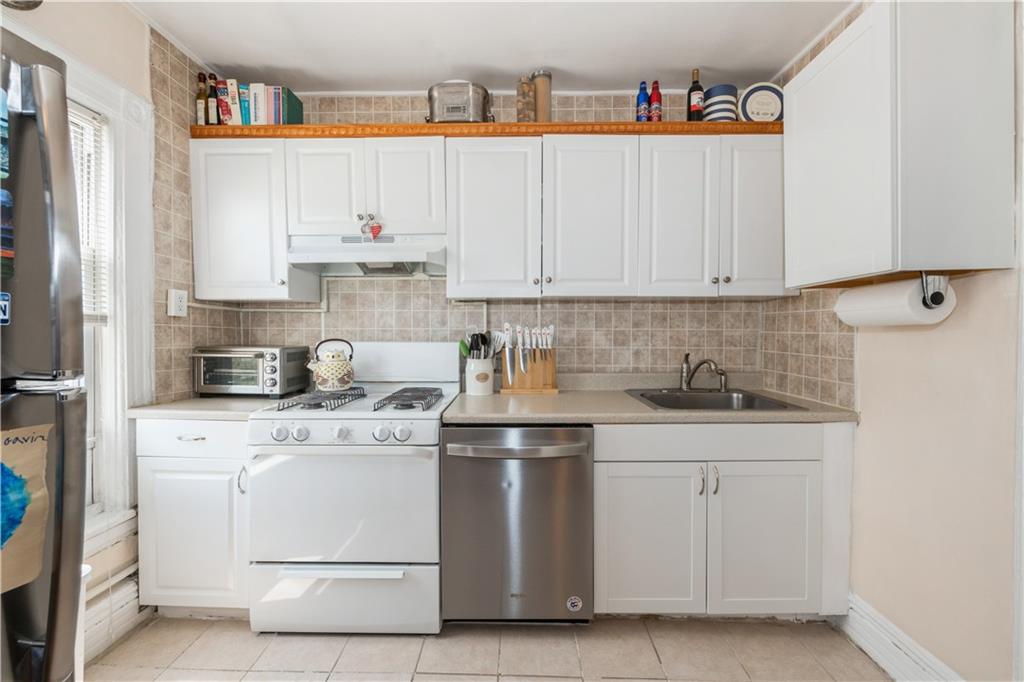 358 74th Street Brooklyn, NY 11209 - Photo 34 of 41 a kitchen with cabinets appliances and a sink