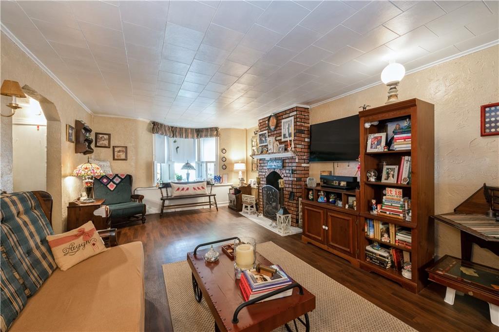 358 74th Street Brooklyn, NY 11209 - Photo 10 of 41 a living room with furniture a flat screen tv and a bookshelf