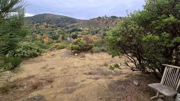 a view of a yard with mountain and wooden fence