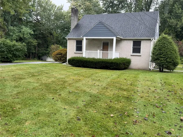 a front view of a house with yard and green space