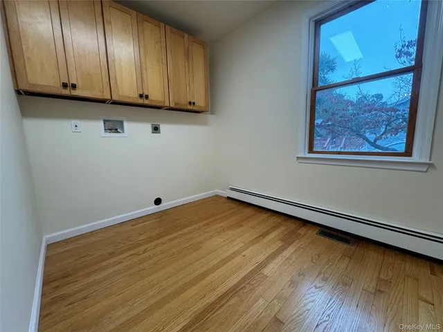 a view of a large kitchen with stainless steel appliances wooden floor and a large window