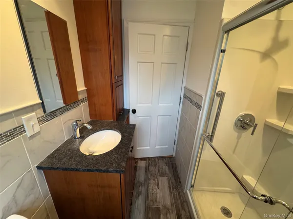 a bathroom with a glass shower door and a sink