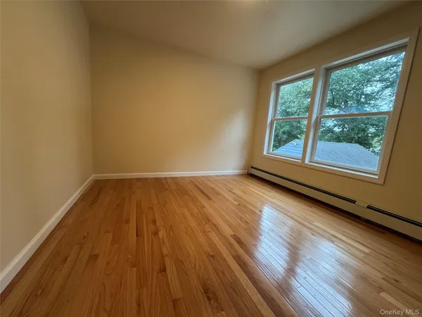 a view of a room with wooden floor and brick walls
