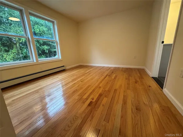 a view of a room with wooden floor and window