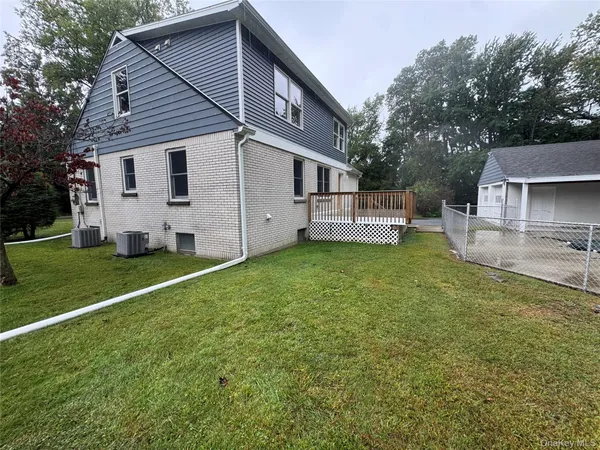 a front view of a house with a yard and tree