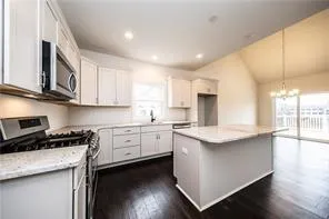 a kitchen with granite countertop white cabinets and white appliances