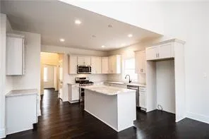 a kitchen with stainless steel appliances granite countertop a stove a sink and a refrigerator