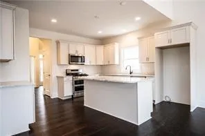 a kitchen with a refrigerator and a stove top oven