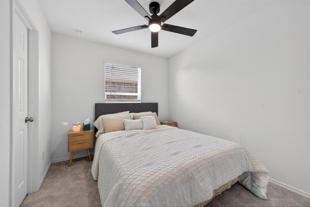2081 Henrietta Drive Forney, TX 75126 - Photo 21 of 34 a bedroom with a bed and a ceiling fan