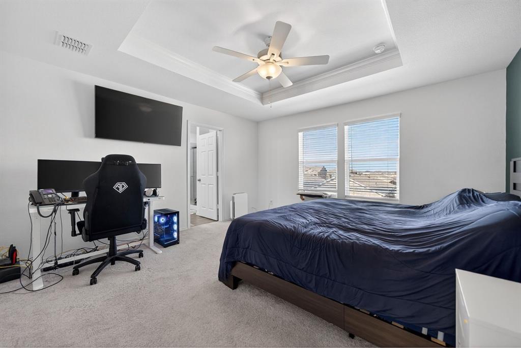 2081 Henrietta Drive Forney, TX 75126 - Photo 24 of 34 a bedroom with a bed a desk and a chandelier