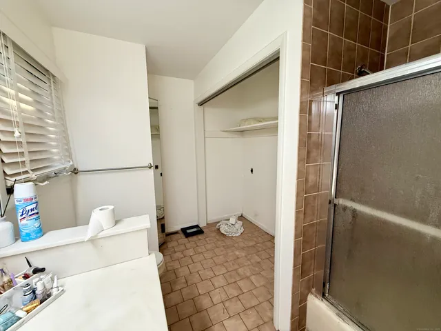 a bathroom with a granite countertop sink a toilet and shower