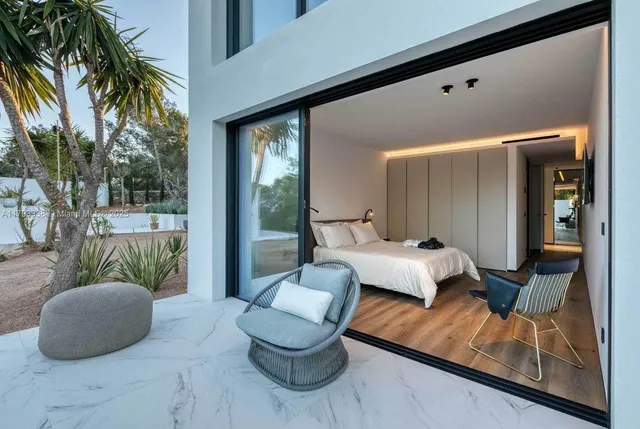 a bedroom with a bed couch and mirror on the wall