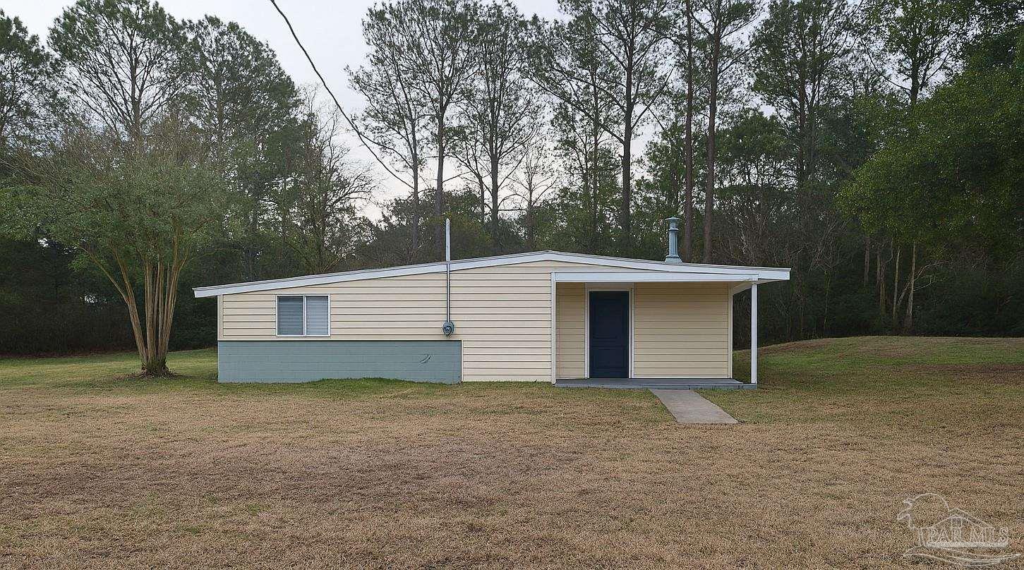 6274 Munson Highway Milton, FL 32570 - Photo 2 of 26 a front view of a house with a yard and garage