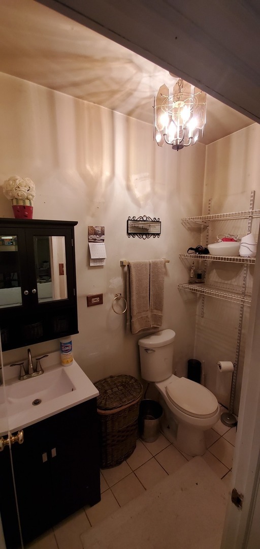9315 South Clyde Avenue Chicago, IL 60617 - Photo 11 of 32 a bathroom with a toilet sink and mirror