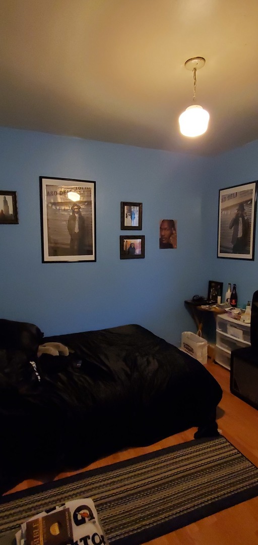 9315 South Clyde Avenue Chicago, IL 60617 - Photo 17 of 32 a bed sitting in a bedroom next to a window
