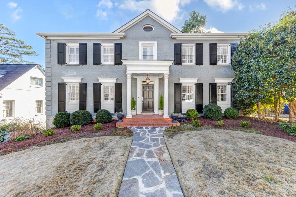 a front view of a house with yard and potted plants